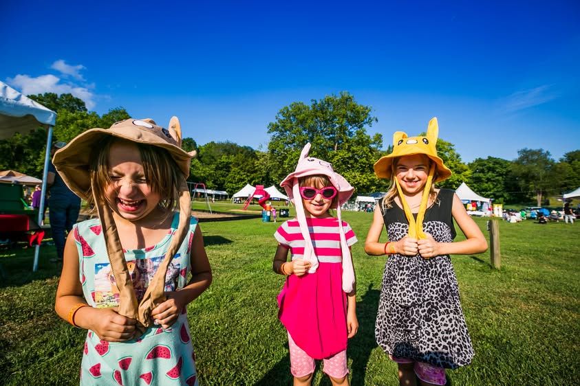 Three children wearing colorful handmade hats at PaoliFest