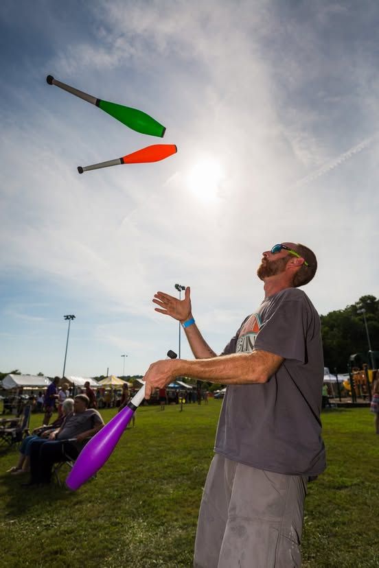 A juggler performing outdoors for the PaoliFest audience