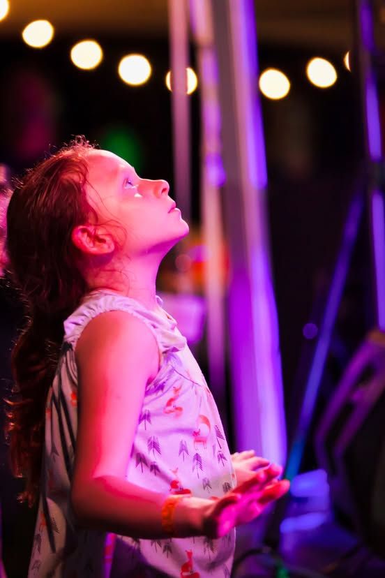 A young singer performing under the PaoliFest stage lights